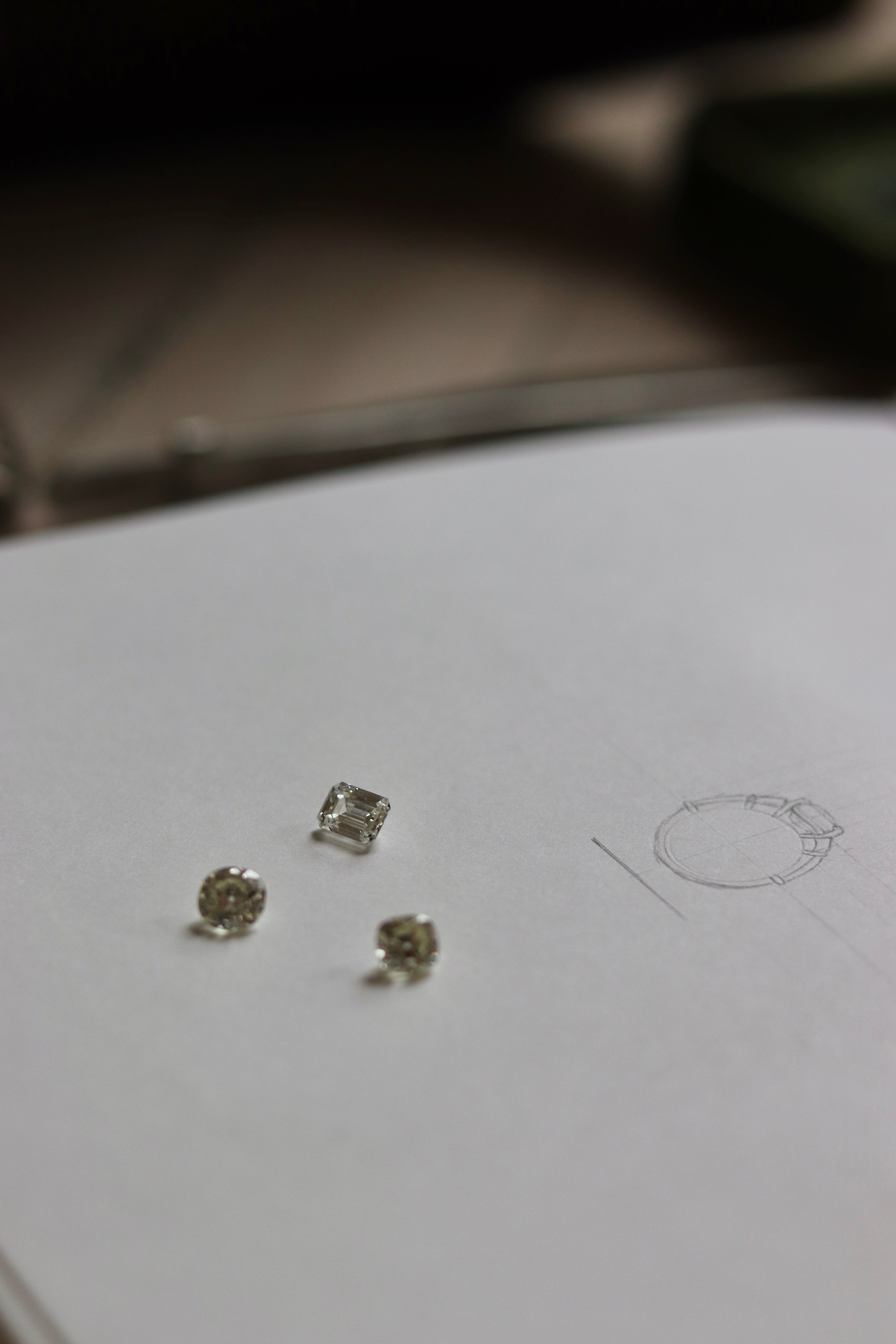 Lab grown emerald cut diamond, and two natural old mine cut diamonds on bespoke drawing sketch book
